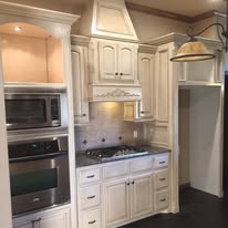 Finished cream glazed kitchen cabinets with ornate trim