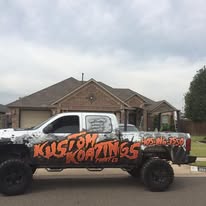 Kustom Koatings work truck parked in front of a residential home