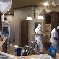 Painting crew prepping a kitchen with protective sheeting