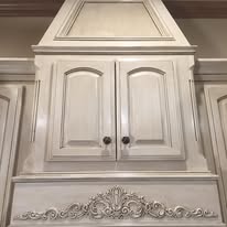 Detail of an ornate cream glazed cabinet with decorative trim