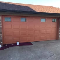 Garage door finished with a faux orange-red wood-grain coating