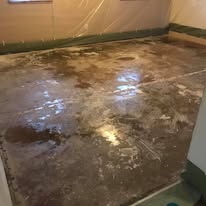 Raw stained concrete floor mid-preparation