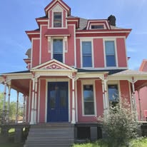 Victorian house exterior freshly painted in red with white trim